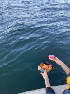 大分海洋散骨の様子。女性が花を海にながしています