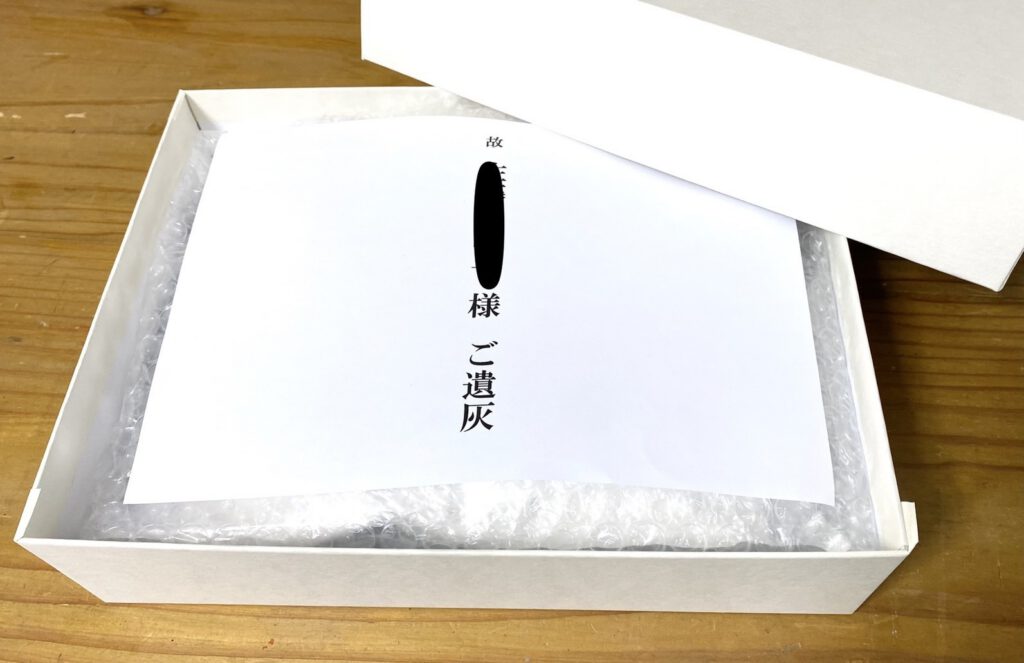 大分で遺骨を粉骨して真空パックへ入れます。真空パックに入れた遺骨を化粧箱へ納めてコンパクトにします。縦幅24㎝×横幅18㎝×高さ5.5㎝の化粧箱へ納めます。